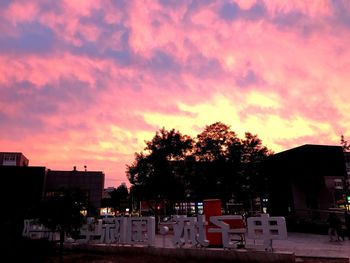 Silhouette of trees in town against sky