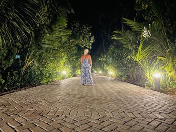 Full length rear view of woman standing on footpath