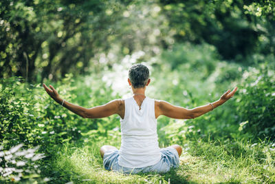 Inner peace meditation. mindful woman meditating with open arms, sitting on the ground
