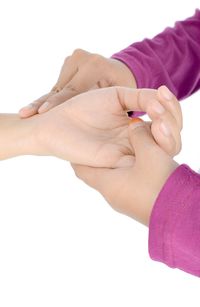 Close-up of hands holding purple over white background