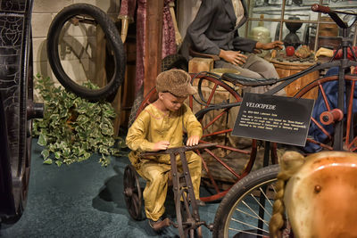 Rear view of man with bicycle sitting in store