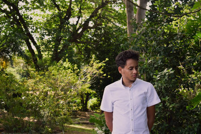 Mid adult man standing against trees