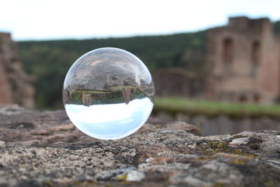 Close-up of crystal ball on field against building