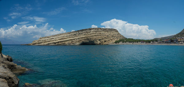 Panoramic view of sea and rocks against blue sky