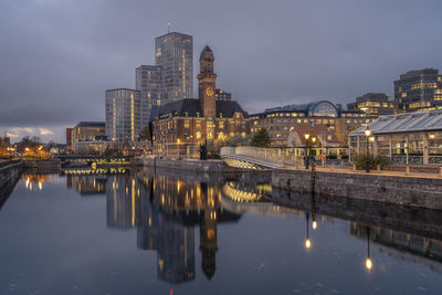 Sweden, skane county, malmo, city canal at dusk with world maritime university and hotels in background