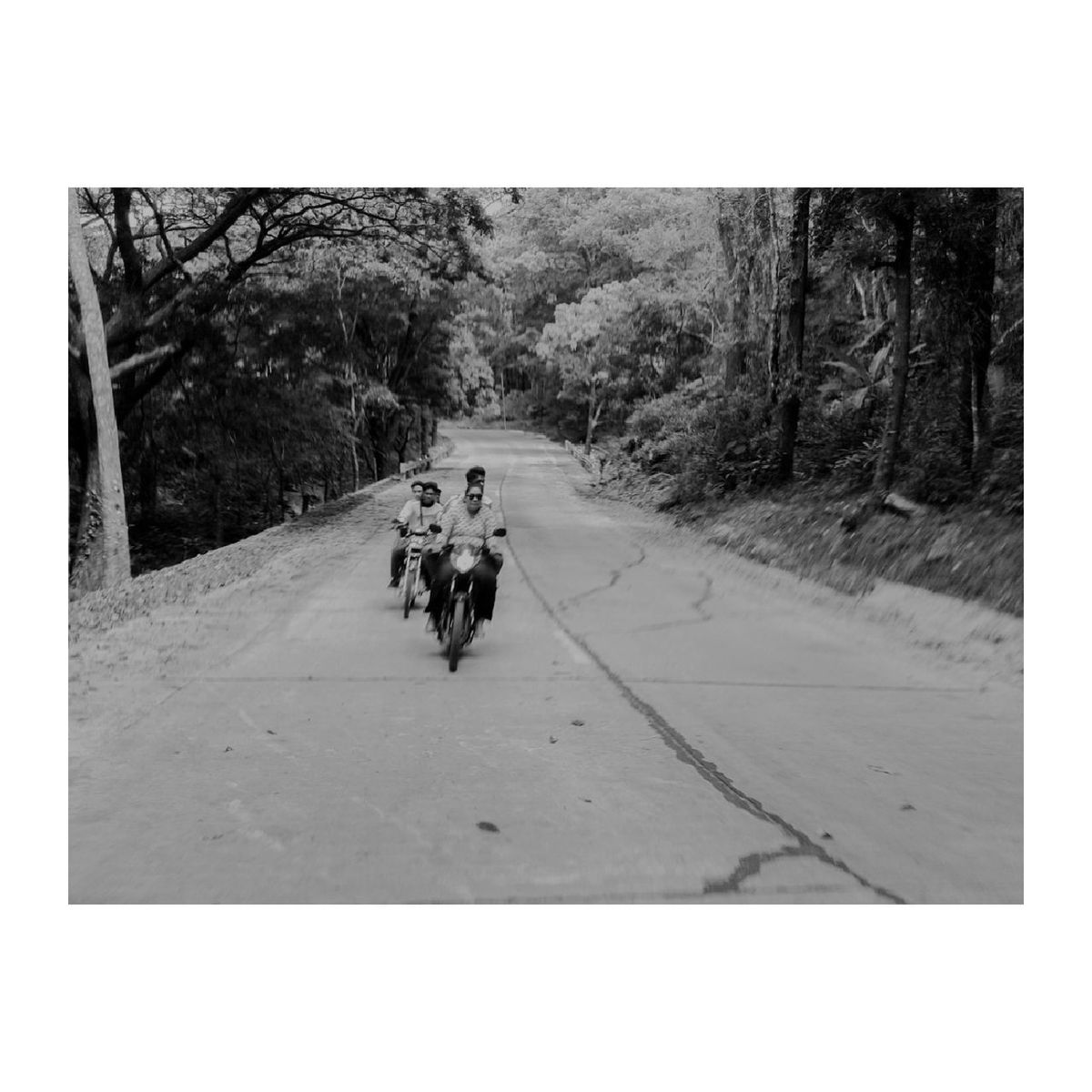 REAR VIEW OF FATHER AND SON RIDING ON ROAD