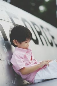 Boy sitting on airplane in museum