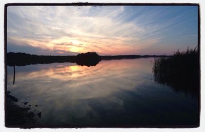 Reflection of clouds in lake at sunset