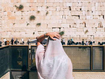 Rear view of woman praying against men section at western wall