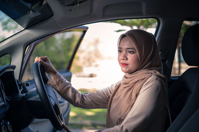 Portrait of woman sitting in car