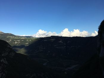 Scenic view of mountains against blue sky