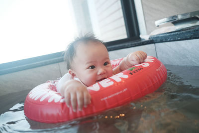 Portrait of cute baby boy in swimming pool