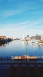 Scenic view of river by buildings against sky