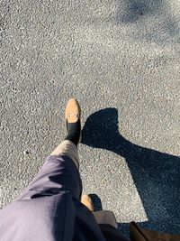 Low section of woman walking on road