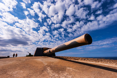 Low section of people on land against blue sky