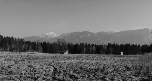 Scenic view of field in front of mountains against clear sky