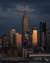 Modern buildings in city against cloudy sky