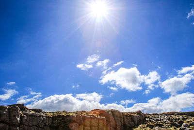 Low angle view of rocks against sky on sunny day