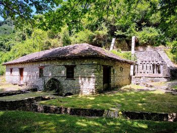 Abandoned house on field by trees