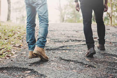 Low section of men walking on land