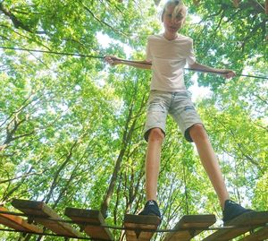 Low angle view of girl in forest