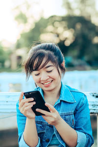 Young woman using mobile phone outdoors