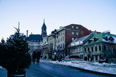 Snow covered city against clear sky