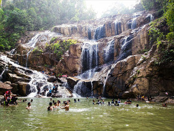 People swimming in waterfall