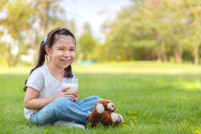 Portrait of smiling girl sitting on field