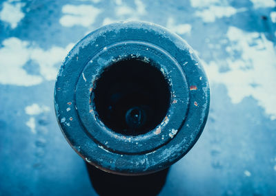 Close-up of metallic object against blue sky