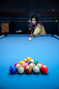 Portrait of woman playing pool