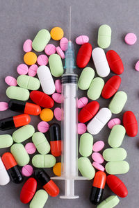 High angle view of medicines with syringe on table