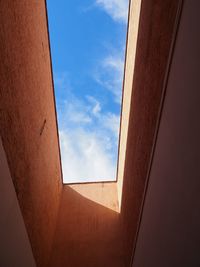 Low angle view of skylight in building against sky