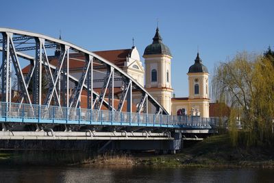 Low angle view of bridge over river against buildings