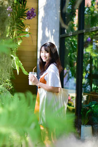 Young woman smiling while holding plants in water