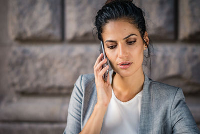Close-up of young woman using smart phone outdoors
