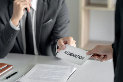 Midsection of man holding text on paper