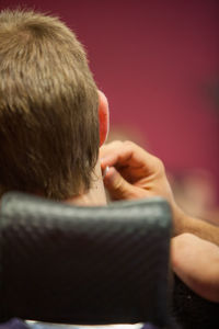 Rear view of man sitting on floor