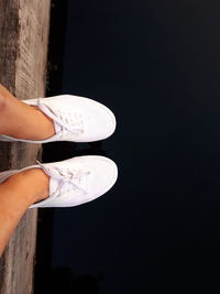 Low section of woman standing on wood