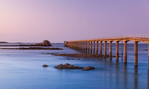 Bridge over sea against clear sky