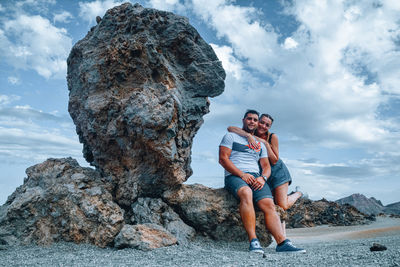 Full length of man standing on rock against sky