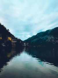 Scenic view of lake by mountains against sky
