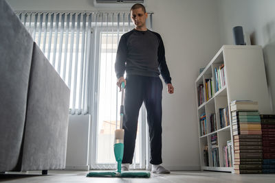 Portrait of young man standing at home