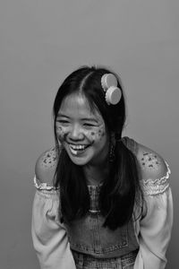 Portrait of smiling girl standing against gray background