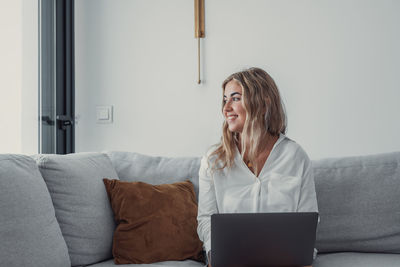 Young woman using digital tablet while sitting at home