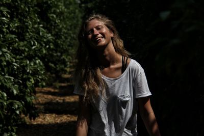 Portrait of smiling young woman standing at park