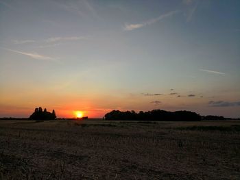 Scenic view of silhouette field against sky during sunset