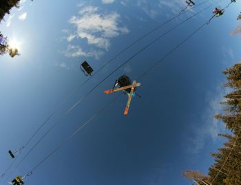 Skiers using ski lift seen from below