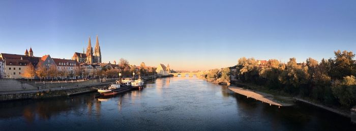 River amidst buildings in city against clear sky