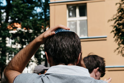 Rear view of man standing against building